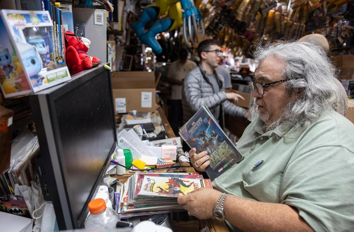 Jorge Perez, 59, store owner, rings up a customer at A&M Comics and Books on Friday, Jan. 24, 2025, in Miami.