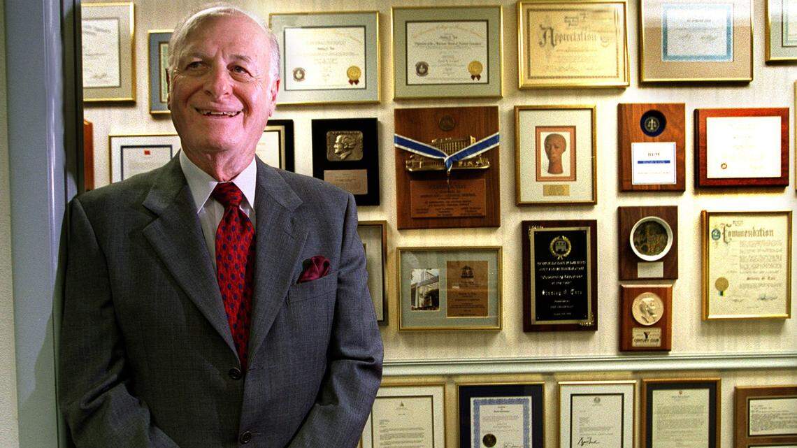 In this file photo from Oct. 11, 2000, Stanley Tate of Tate Enterprises, a developer who founded the Florida Prepaid College program, stands in front of a wall of his acknowledgments in his North Miami office.