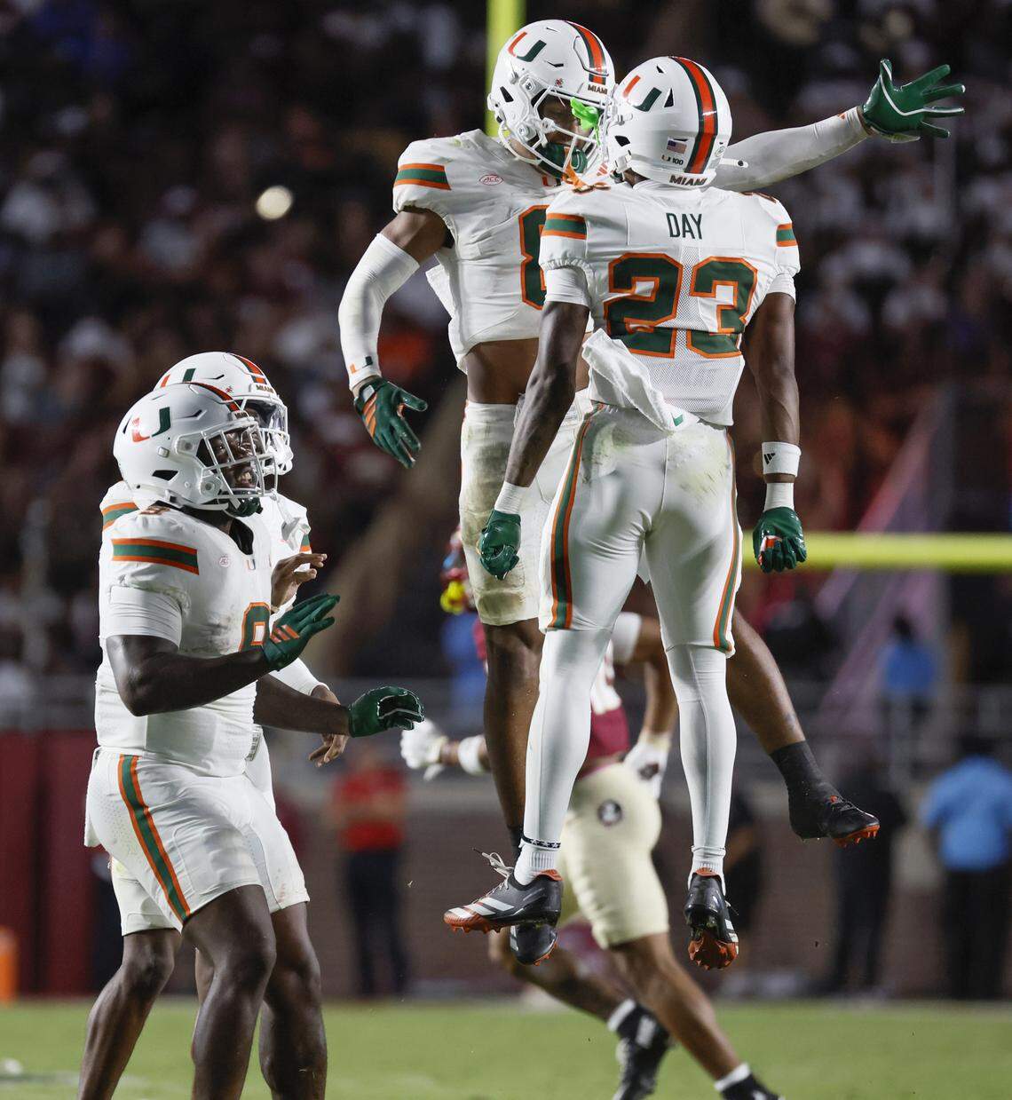 Miami Hurricanes defensive back Dylan Day (23) celebrates with defensive back Jakobe Thomas (8) after Day tackles Florida State Seminoles wide receiver Squirrel White (4) during the second half of their NCAA game at Doak Campbell Stadium in Tallahassee, Florida, on Saturday, October 4, 2025.