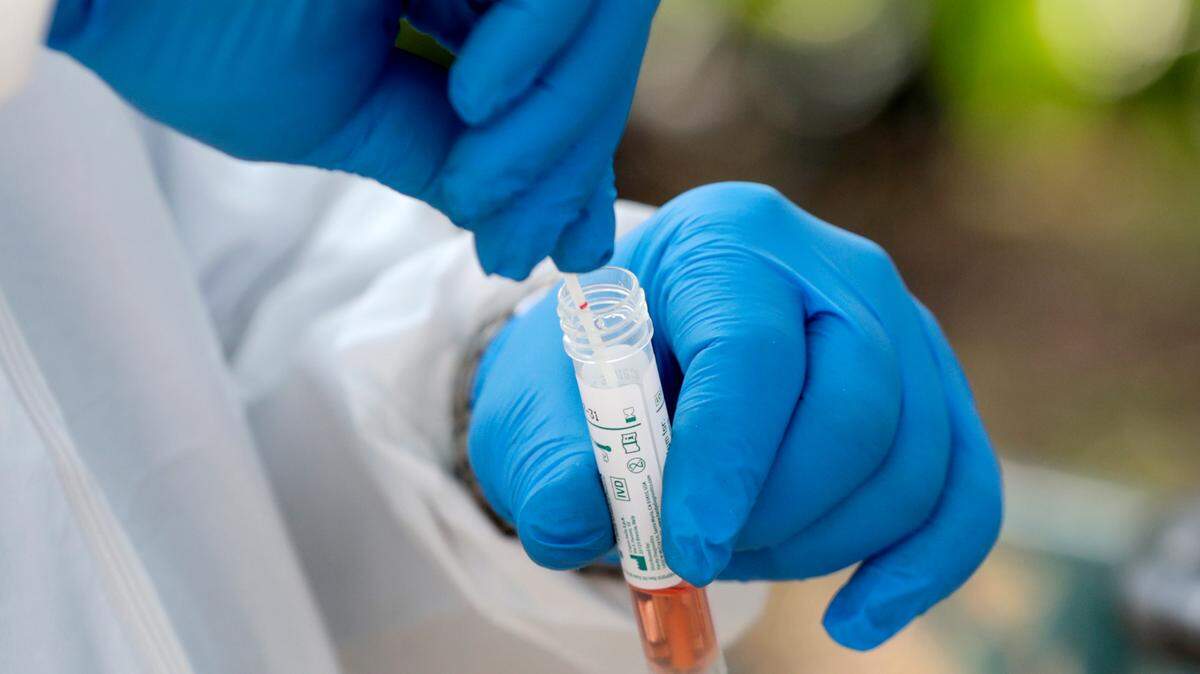 A medical worker places a swab in a vial while testing the homeless for COVID-19 through the Miami-Dade County Homeless Trust, during the new coronavirus pandemic, Thursday, April 16, 2020, in Miami.