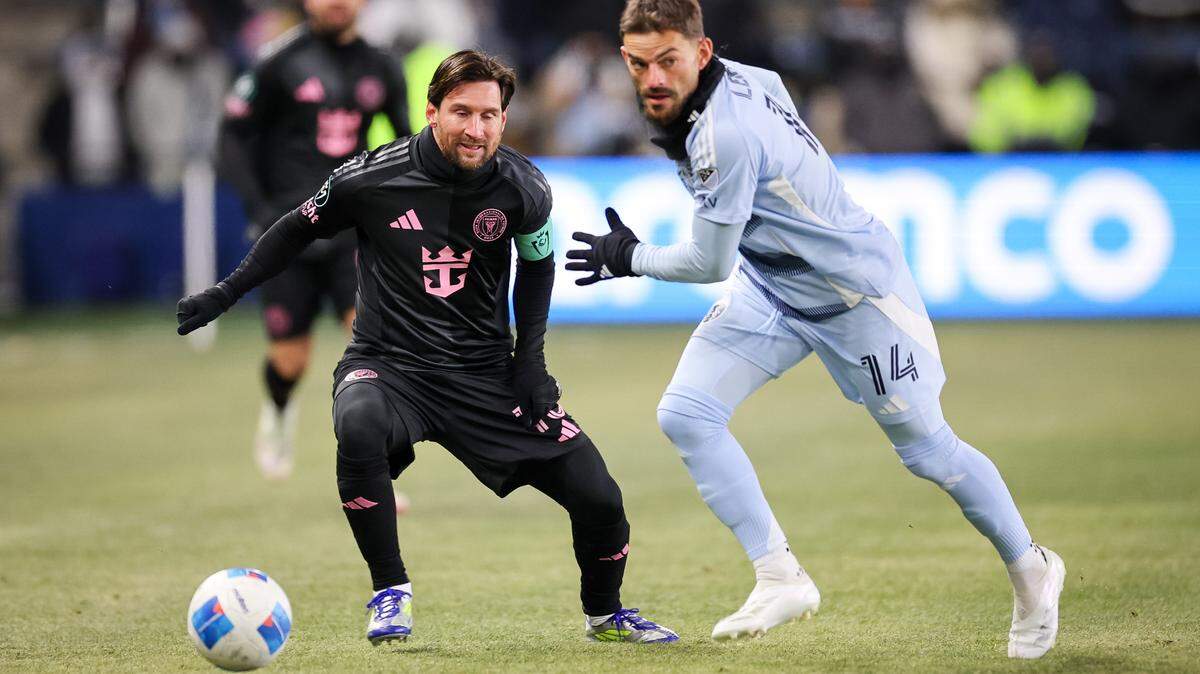 Feb 19, 2025; Kansas City, Kansas, USA; Inter Miami forward Lionel Messi (10) and Sporting Kansas City defender Tim Leibold (14) go after the ball during the first half at Children’s Mercy Park, a game that was played in sub-zero temperatures.
