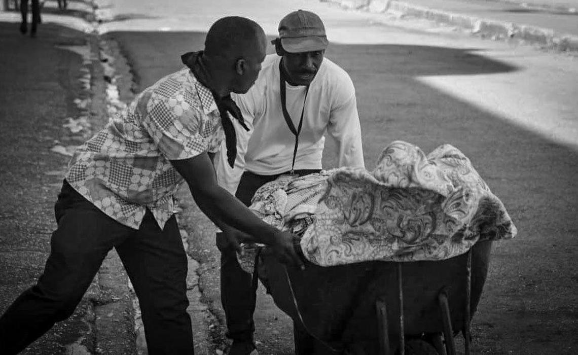 Two men push a wheelbarrow containing the body of the brother of the man on the left. Gangs once more launched fresh attacks in Haiti on Tuesday, February 25, 2025.