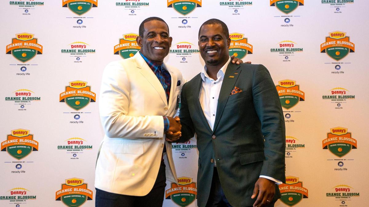 Jackson State University head coach Deion Sanders, left, and Florida A&M University head coach Willie Simmons, right, shake hands during a pregame press conference for the Orange Blossom Classic held on the Club Level at Hard Rock Stadium in Miami Gardens, Florida, on Friday, September 2, 2022.