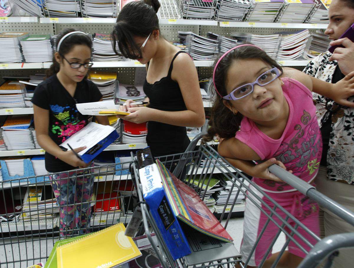 In this file photo from Aug. 12, 2009, grade school students and their mom shopped for back-to-school supplies at a South Florida Walmart.