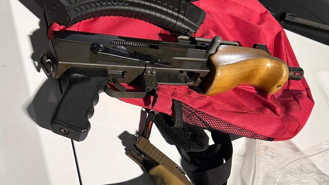 A mini AK-47 and a Glock pistol are displayed on the hood of a Monroe County Sheriff’s Office patrol car Sunday, Feb. 2, 2025. The sheriff’s office said the weapons were found during a traffic stop, and the driver of the car has a felony conviction, making it illegal for him to possess the firearms.