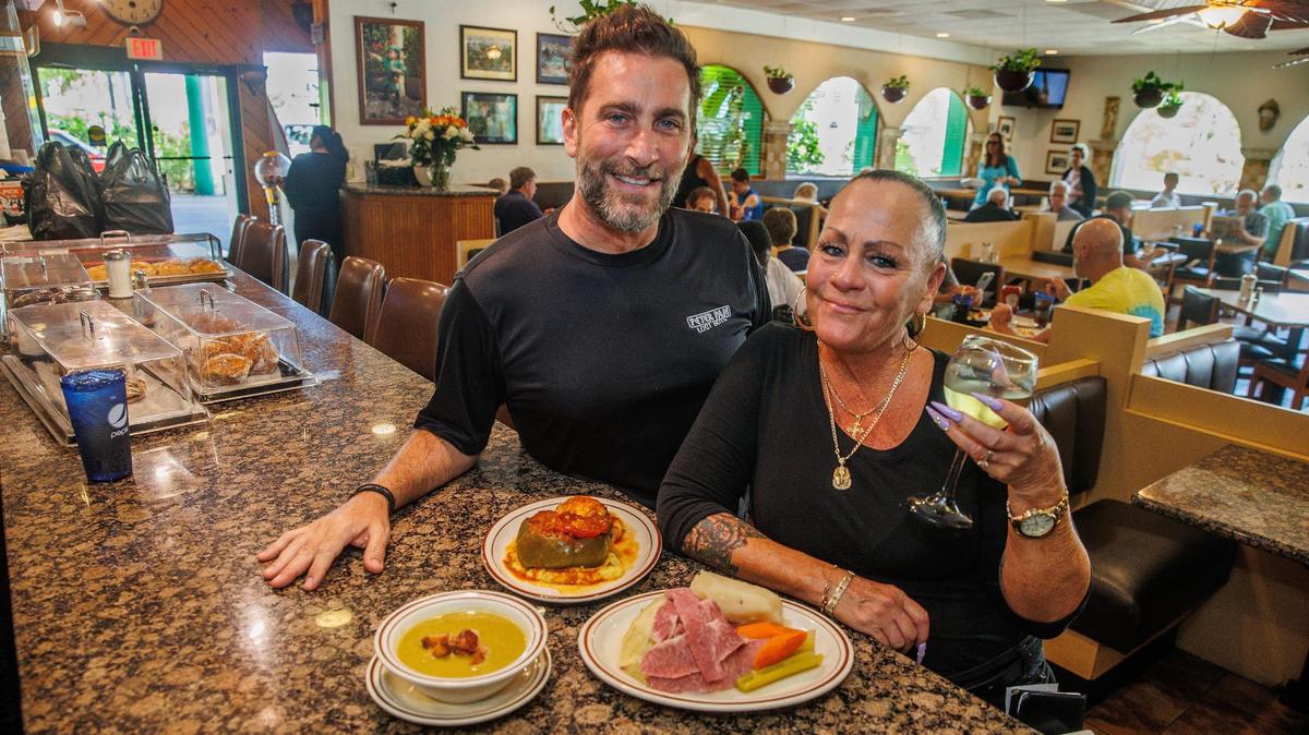 Jeronimos Kourkoumelis, owner of the Peter Pan Diner in Oakland Park, and long-time employee Barbara Rogers display some of the daily specials from the menu, including split pea soup, stuffed peppers and corned beef and cabbage.