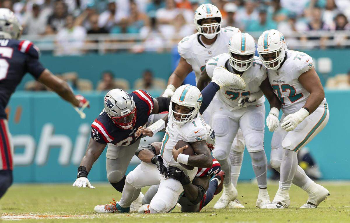 Miami Dolphins quarterback Tua Tagovailoa (1) is sacked in the second half of his NFL game against the New England Patriots at Hard Rock Stadium on Sunday, Sept. 14, 2025, in Miami Gardens, Fla.