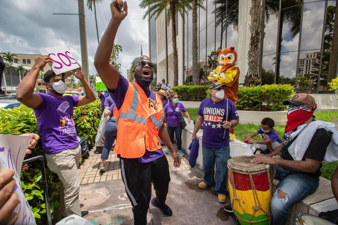Service Employees International Union, Local 32BJ organizer, Andy Cabrera, leads laid off workers from airline contractor Eulen America in a chant as they hold #SOSAmericanAirlines protest in front of America Airlines building in Coral Gables on Thursday, June 25, 2020.