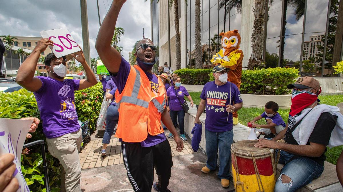 Service Employees International Union, Local 32BJ organizer, Andy Cabrera, leads laid off workers from airline contractor Eulen America in a chant as they hold #SOSAmericanAirlines protest in front of America Airlines building in Coral Gables on Thursday, June 25, 2020. The company briefly had its contract cancelled by Miami-Dade County before agreeing to workplace improvements.