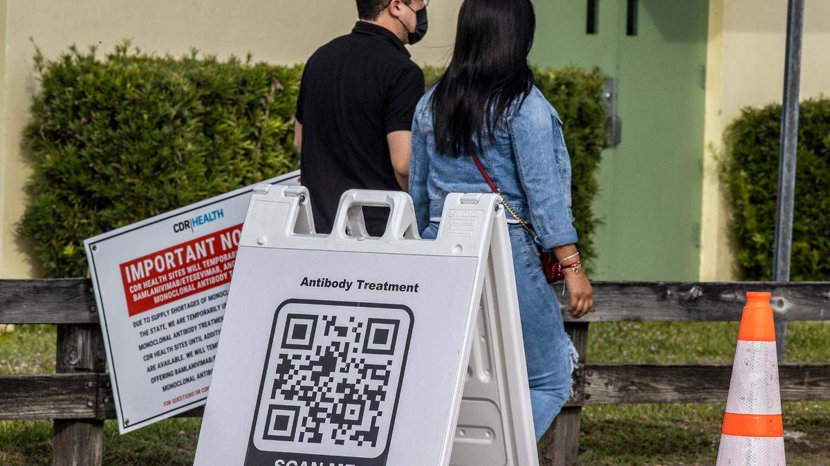 Una pareja se dirige a un centro de tratamiento del COVID-19 en donde distribuyen anticuerpos monoclonales, el martes 4 de enero de 2022 en Tropical Park, Miami. 