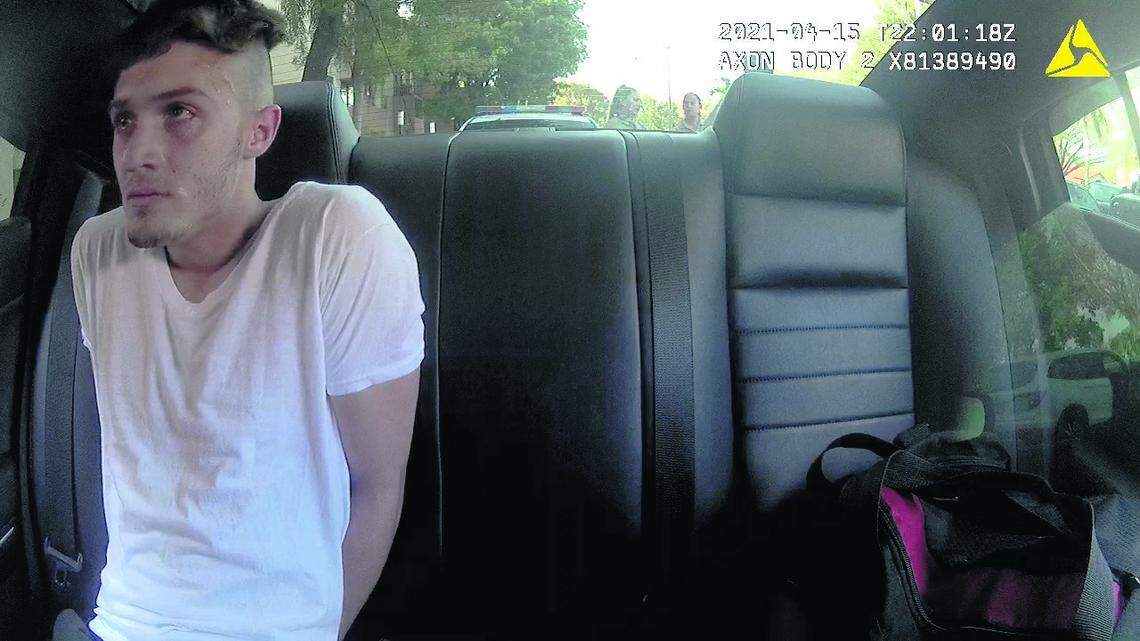 Richard Hollis sits in the back of a police car after having been arrested on April 15, 2021.