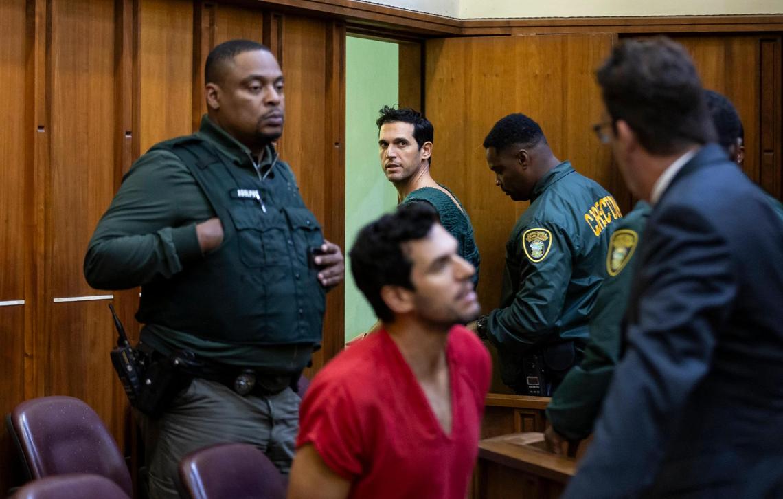 Alon Alexander, 37, heading toward the door, and his twin brother, Oren, in a red jail jumpsuit, try to talk to their attorney Joel Denaro after their bond hearing on Friday, Dec. 13, 2024, in Miami, Fla. The Alexanders have been charged with multiple state and federal crimes, including sex trafficking and rape.