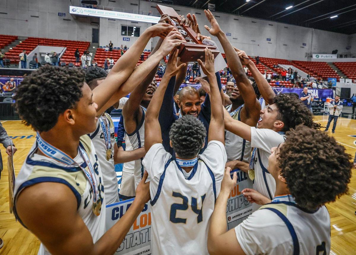 Calvary Christian School’s head coach Clik McSweeney and the team hold up the championship trophy after defeating the Villages for the FHSAA Class 3A Boys High School Basketball State Championship at the RP Funding Center in Lakeland, Florida on Saturday, March 1, 2025.