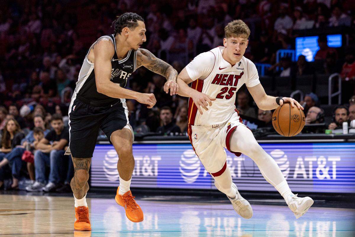 Miami Heat guard Kasparas Jakucionis (25) drives past San Antonio Spurs forward Lindy Waters III (43) during an NBA preseason game at Kaseya Center on October 8, 2025, in Miami.
