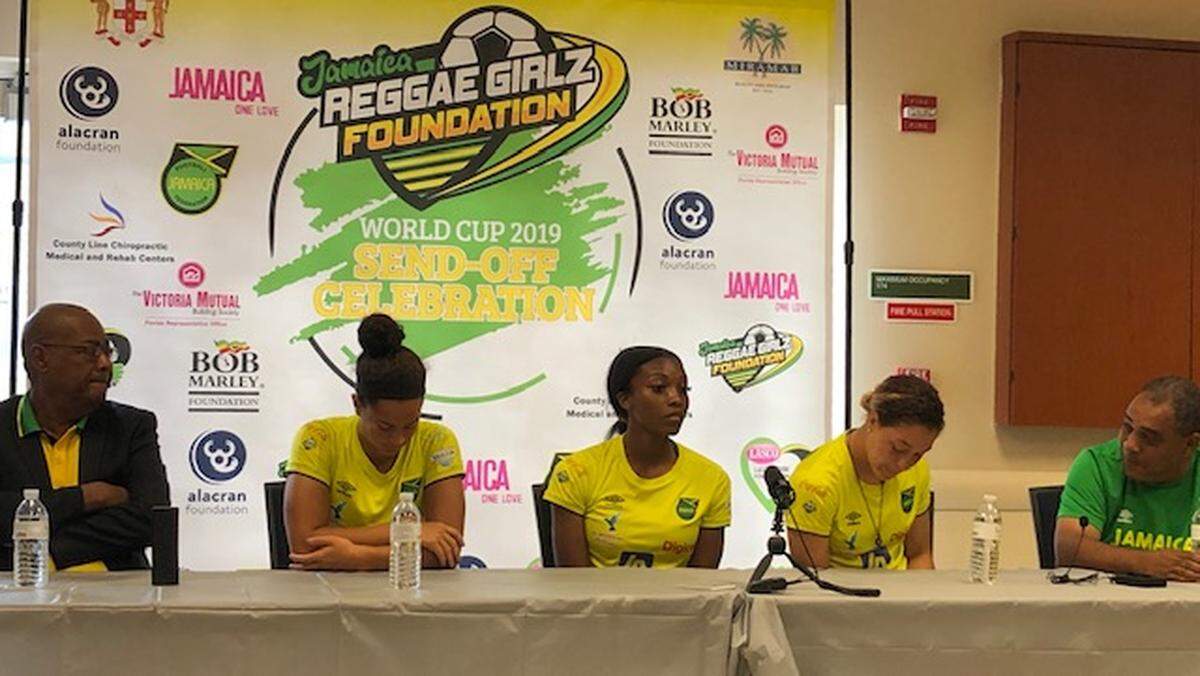 (L-R) Jamaican Football Federation president Michael Ricketts, Reggae Girlz players Kayla McCoy, Cheyna Matthews, Chinyelu Asher, and coach Hue Menzies at a press conference Wednesday at the Ansin Sports Complex in Miramar, Fla.