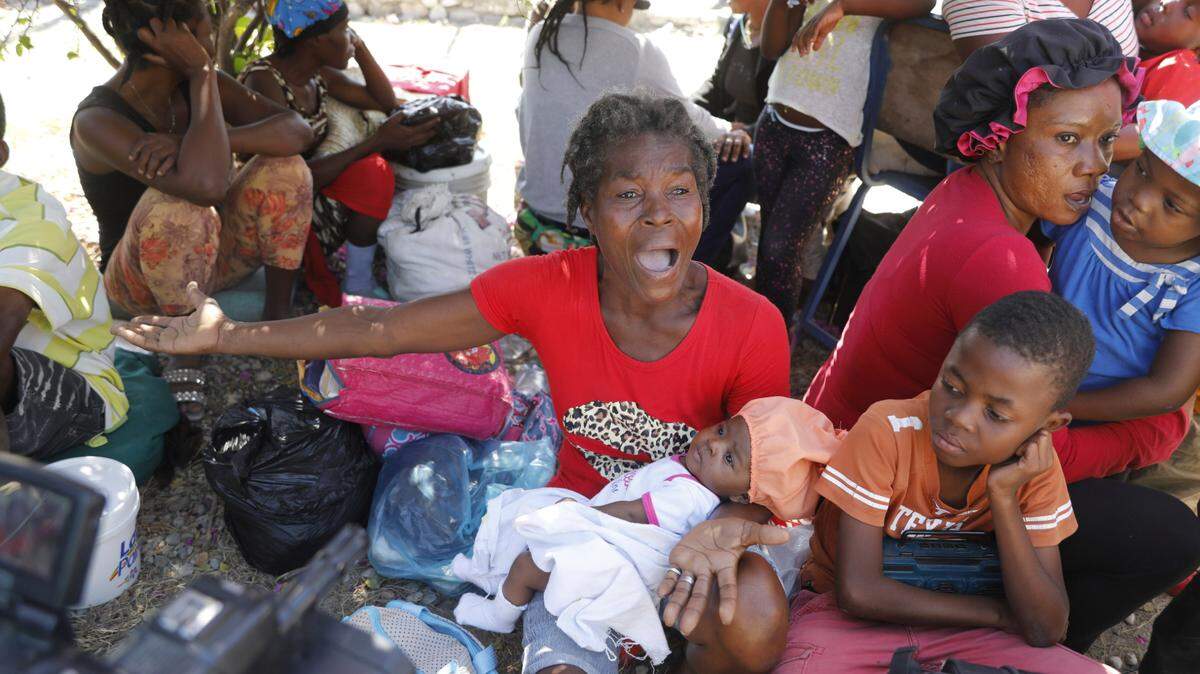 Women and children gather outside a police station after fleeing their homes in Cite Soleil due to gang violence, in Port-au-Prince, Haiti, Monday, Feb. 12, 2024. (AP Photo/Odelyn Joseph)