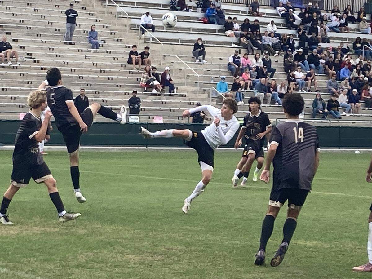 American Heritage’s Artem Torbinskii (white jersey) tries to control a ball during Saturday's Class 4A state boys’ soccer championship match at Spec Martin Stadium in DeLand, Fla.