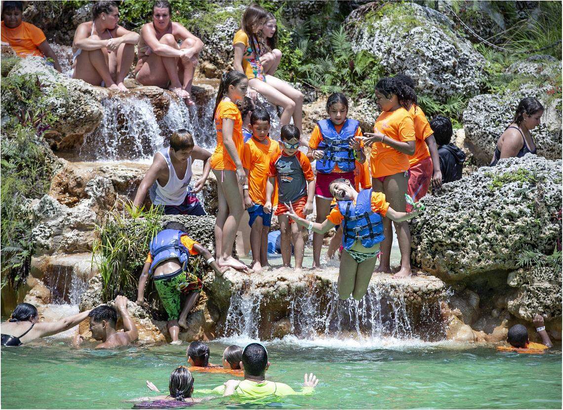 Emily Moore, at center, jumps into the cool 77-degree waters of Venetian Pool in Coral Gables as she participates in the Most Maximizing Out of School Time Summer Camp field trip from Fort Lauderdale’s Center for Hearing and Communication on Friday, June 21, 2019.