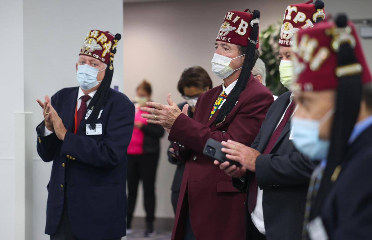 Members of the Shriners group clap during a press conference at Jackson Memorial Hospital on Friday, July 22, 2022. Jackson Health System, University of Miami Health and Shriners Children’s are partnering to open a new pediatric orthopedic center at Jackson.