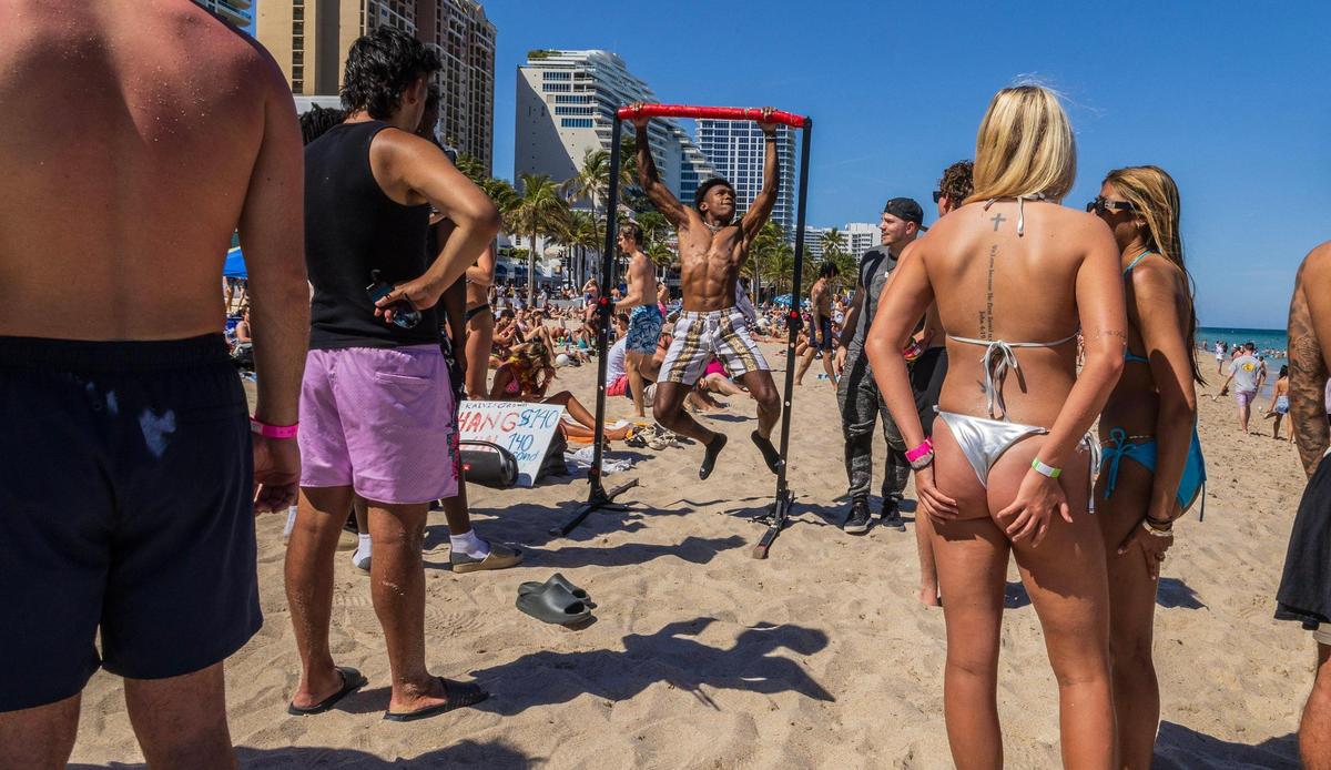 Raivis Ordway (left with hat) keeps count as RJ De-Madet of Texas participates in a hang-to-win contestant during Fort Lauderdale’s spring break on Thursday March 20, 2025.
