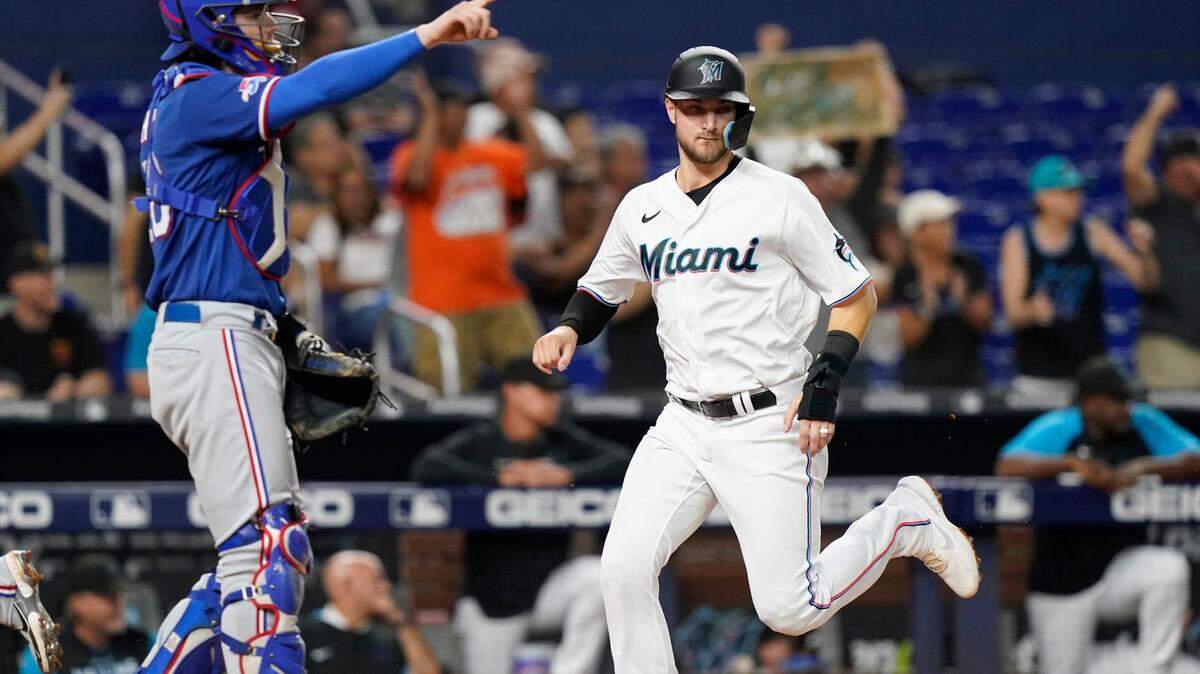 Miami Marlins’ Charles Leblanc, right, scores past Texas Rangers catcher Jonah Heim, left, on a single hit by Jon Berti in the fifth inning during Game 2 of a doubleheader baseball game, Monday, Sept. 12, 2022, in Miami. (AP Photo/Lynne Sladky)