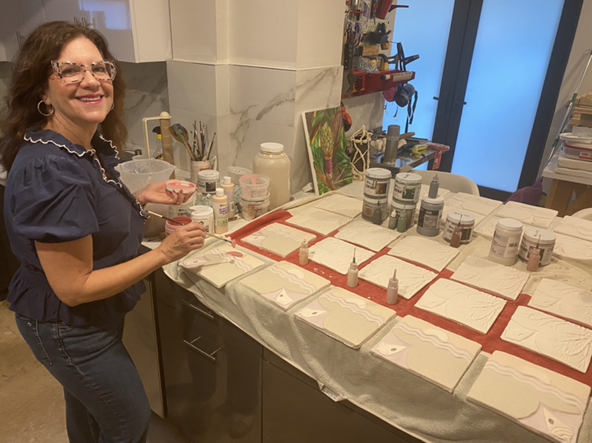 Artist Enma Saiz glazing part of the “Deering Tiles” installation.