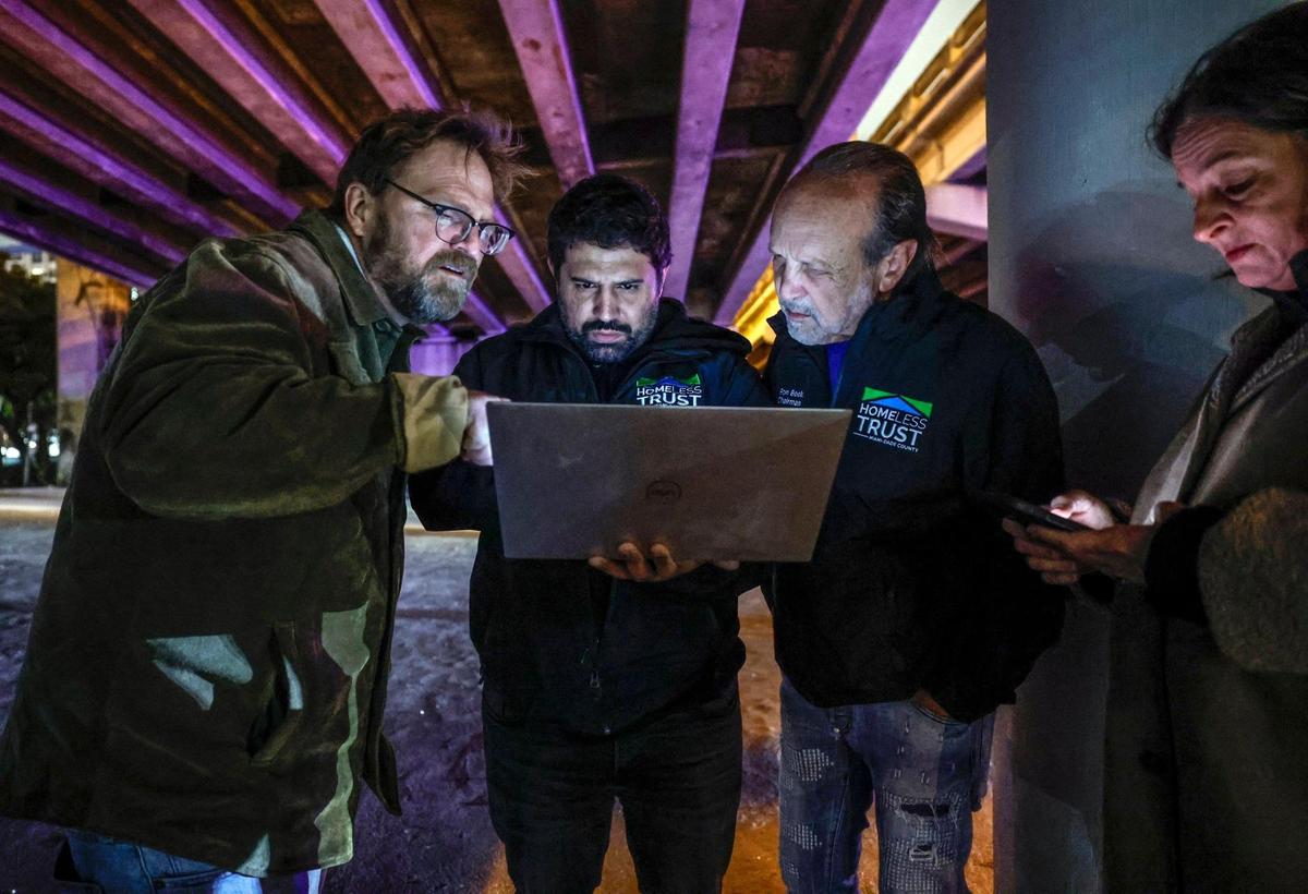 John Quade, William Miranda, Homeless Trust Chairman Ron Book and Trust Executive Director Vicki Mallette, left to right, review data collected during the Homeless Trust’s biannual homeless census in Miami on Friday, Jan. 23, 2025.