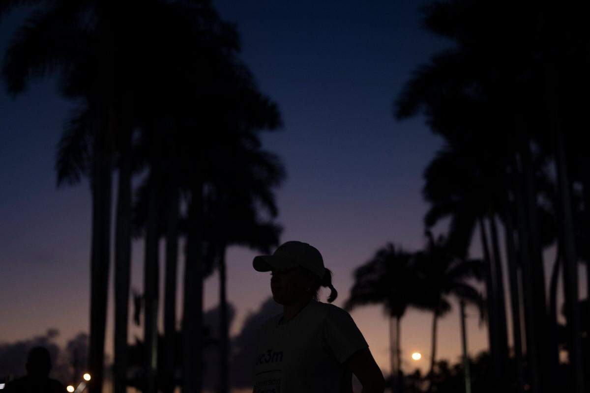 The sun rises over Port Boulevard as a runner in one of the last waves heads to the starting line during the Life Time Miami Marathon and Half on Sunday, Jan. 28, 2024, finishing at Bayfront Park in downtown Miami.
