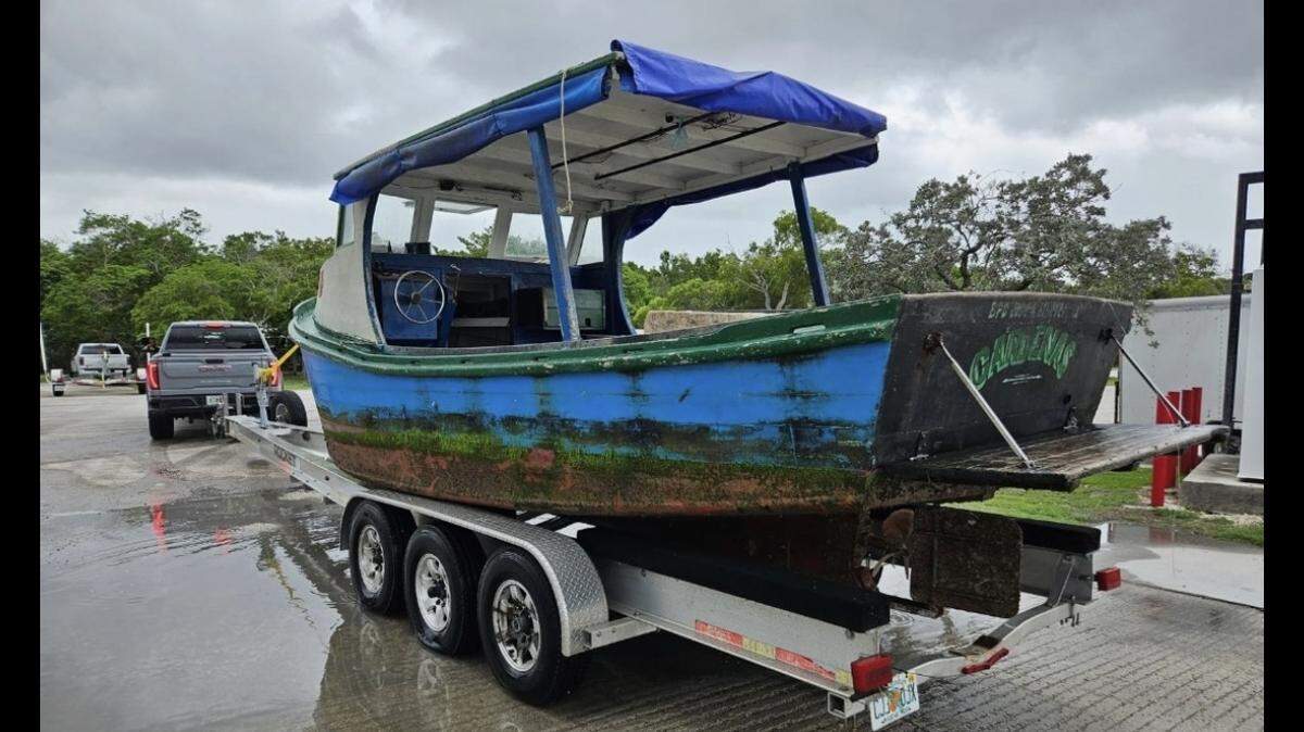 A wooden fishing boat is parked on a trailer at a Florid Keys marina. Authorities say the vessel was used to ferry 10 migrants to the Florida Keys from Cuba Thursday, Sept. 5, 2025.