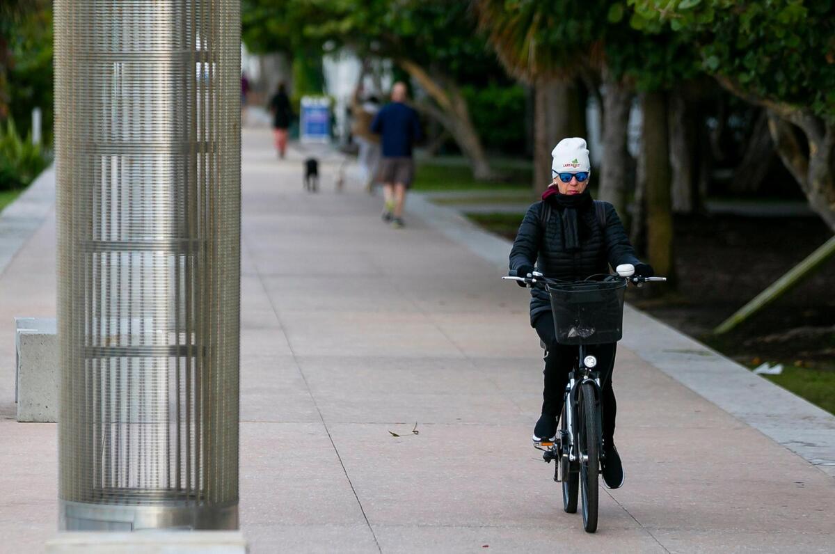 A bicyclist makes her way toward South Pointe Park in Miami Beach as temperatures dip into the low 50s across South Florida on Saturday, January 29, 2022.