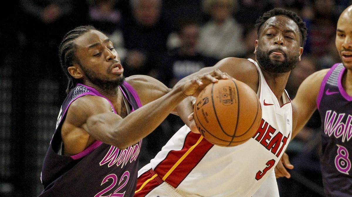 Minnesota Timberwolves forward Andrew Wiggins (22) struggles to control the ball as Miami Heat guard Dwyane Wade (3) defends against him in the third quarter of an NBA basketball game Friday, April 5, 2019, in Minneapolis. (AP Photo/Bruce Kluckhohn)