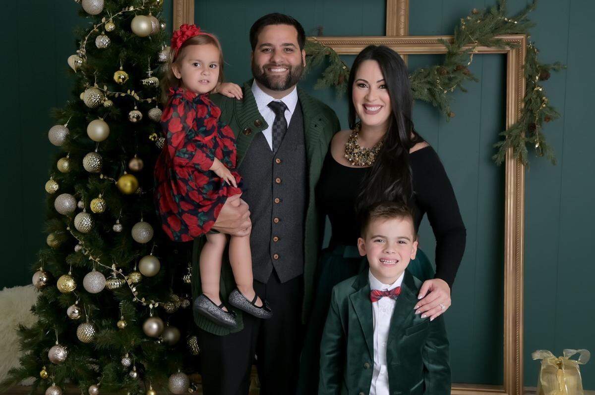 Arnold and Ailyn Cuervo pose for a family photo with their children. Their daughter developed three red-purple quarter size lumps on her thighs following her childhood vaccinations, the lawsuit says.