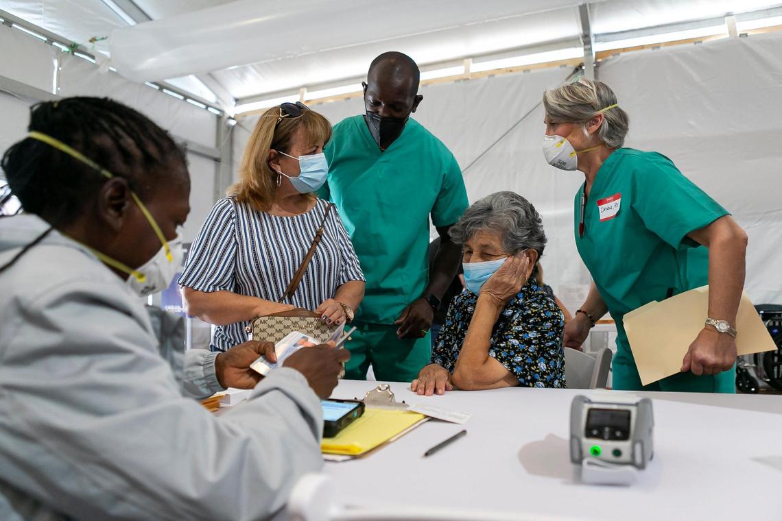 Luz Rincon, 66, center-left, helps her mother, Julia Rincon, 96, center, present identification to receive the Moderna vaccine at a new walk-up COVID-19 vaccination site in Miami’s Overtown neighborhood on Tuesday, March 2, 2021.