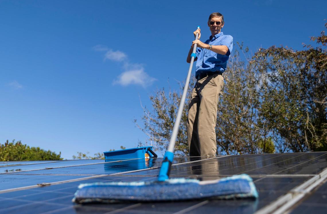 Phil Stoddard, chair of the Green Corridor, cleans the solar panels on his roof on Wednesday, Jan. 31, 2023, in South Miami, Fla.