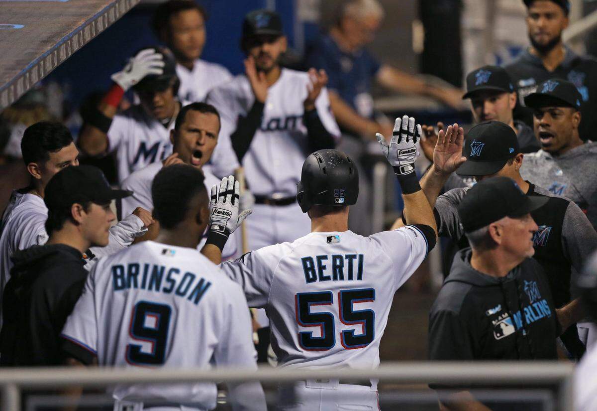Miami Marlins shortstop Jon Berti (55) is congratulate by after hitting a solo home run during the first inning of a Major League Baseball game against the Cincinnati Reds at Marlins Park in Miami on Thursday, August 29, 2019.