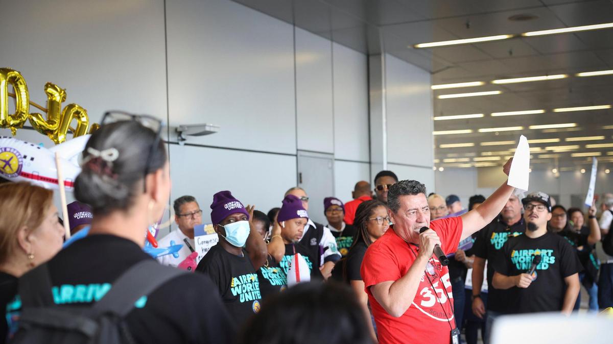 Héctor Canales (derecha), trabajador de  Chili's del aeropuerto y sindicalizado, habla durante una protesta de trabajadores contratados  que exigen mejores salarios, licencia remunerada por enfermedad y otras prestaciones, el lunes 25 de abril de 2022, en el Aeropuerto Internacional de Miami (MIA). 