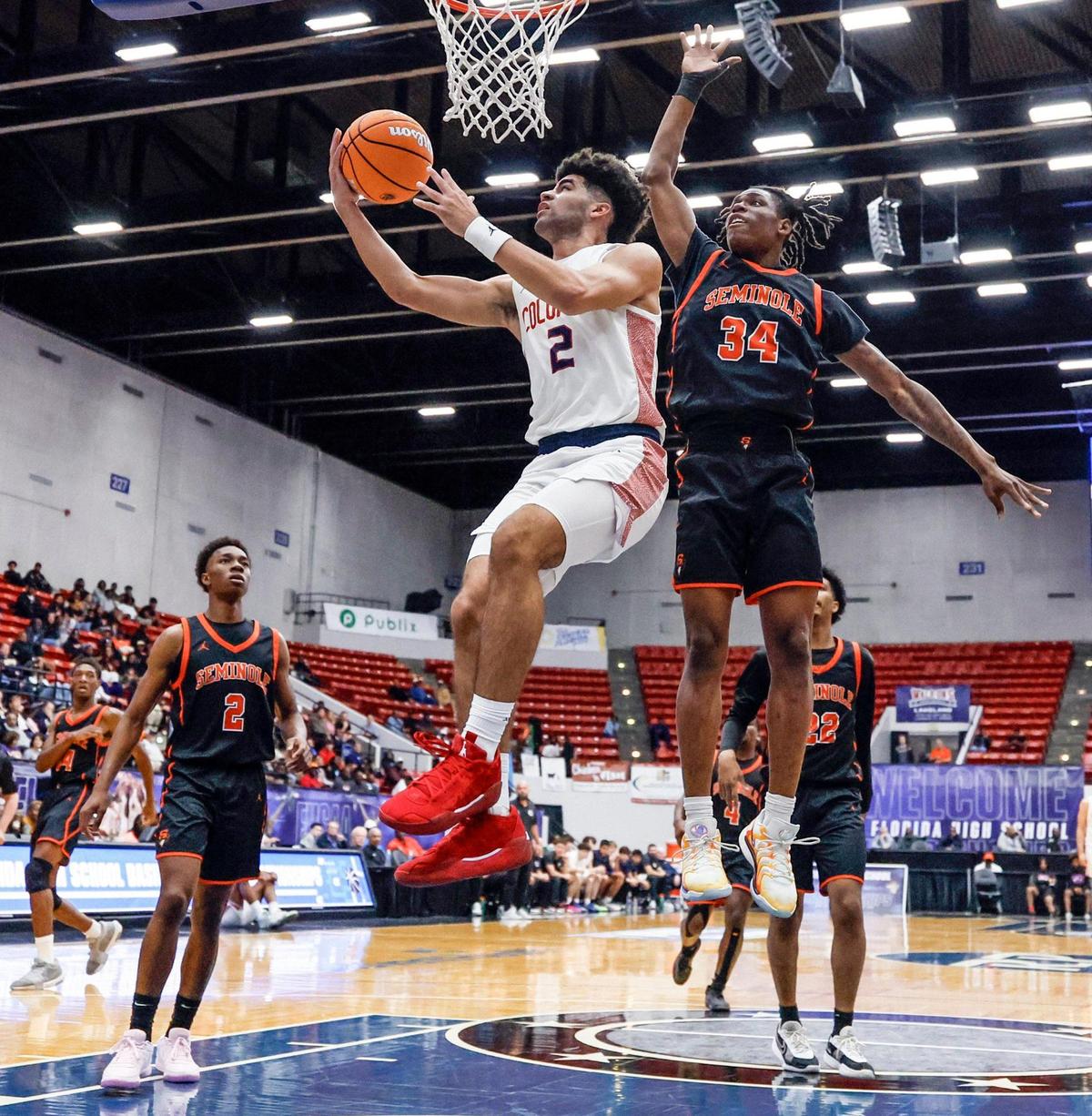 Columbus High School’s Cayden Boozer (2) drives to the basket as Seminole High School’s Jorein O’Neal (34) defends in the first half for the FHSAA Class 7A Semi-Final for Boys High School Basketball State Championship at the RP Funding Center in Lakeland, Florida on Friday, March 7, 2025.