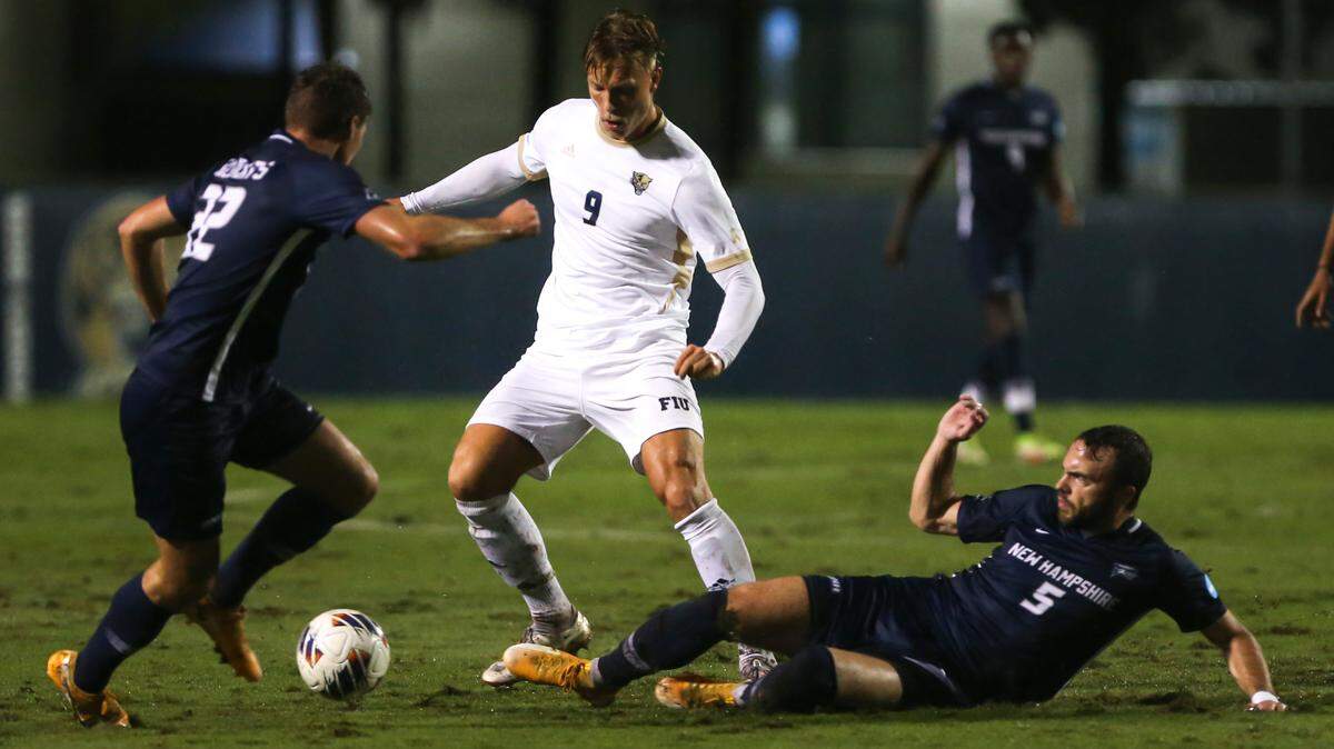 FIU Panthers forward Rasmus Tobinski (9) controls the ball between New Hampshire defender Nils Buchwalder (5) and defender Liam Bennett (22) during the first half of an NCAA soccer tournament game at FIU Soccer Stadium at Florida International University in Miami, Florida, Sunday, November 20, 2022.