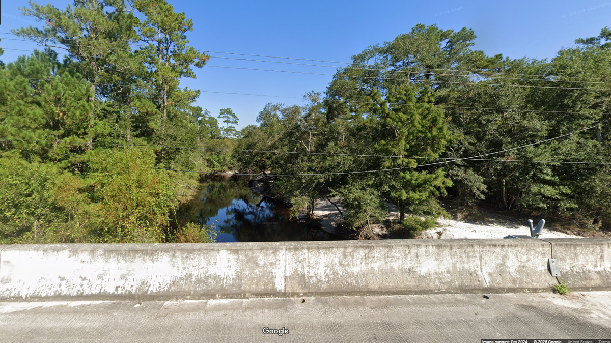 A father and his two daughters were fishing off a bridge in Wakulla County, Florida, when a woman pulled a gun and took them hostage, the sheriff’s office says.
