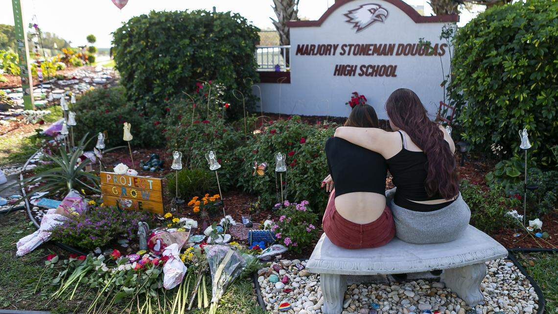 Jess Shanahan, 17, puts her arm around her friend, Lauryn Augustyne, 19, as they visit a makeshift memorial outside of Marjory Stoneman Douglas High School on Friday, February 14, 2020 during the two-year anniversary of the Parkland shooting where 17 victims were killed.