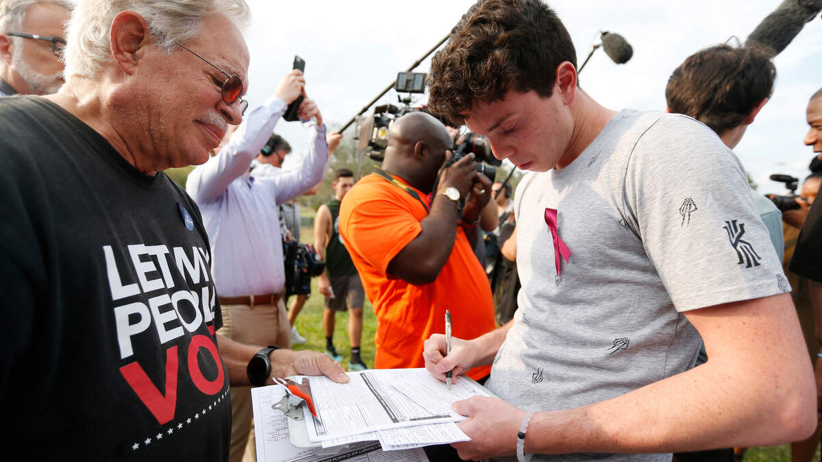 Volunteer Alan Ehrlich, left, helps Harrison Arnberg, 18, an American Heritage high school senior, register to vote at Weston Regional Park, on Friday, March 2, 2018. Arnberg said he registered because he wants the state to ban semiautomatic weapons like the one used in the Feb. 14 shooting in Parkland.