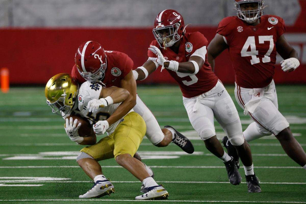 Notre Dame running back Chris Tyree (25) is stopped by Alabama defensive back Patrick Surtain II (2) with help from defensive back Jordan Battle (9) and defensive lineman Byron Young (47) in the second half of the Rose Bowl NCAA college football game in Arlington, Texas, Friday, Jan. 1, 2021. (AP Photo/Ron Jenkins)