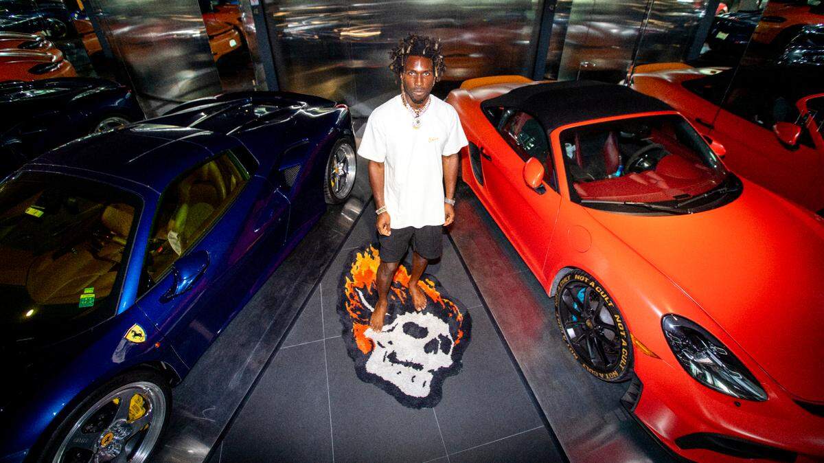 Carlos St. John Phillips, known professionally as SAINt JHN, a Guyanese-American rapper, singer and songwriter stands next to his two cars at his home in Sunny Isles Beach, Florida, on Monday, August 2, 2021.