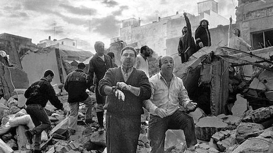 Emergency workers and others walk over the rubble left after a bomb exploded at the AMIA Jewish center in Buenos Aires, Argentina, in 1994.