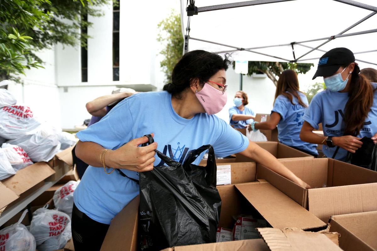Leticia Kalb, volunteers preparing bags of food during a kosher food distribution event at the Greater Miami Jewish Federation parking lot in response to widespread economic hardship and food insecurity brought on by the COVID-19 pandemic, in Miami, Florida Friday, October 16, 2020.