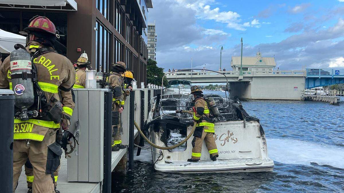Fort Lauderdale firefighters finish extinguishing flames on a boat docked in the Intracoastal Waterway Sunday, Oct. 12, 2025.