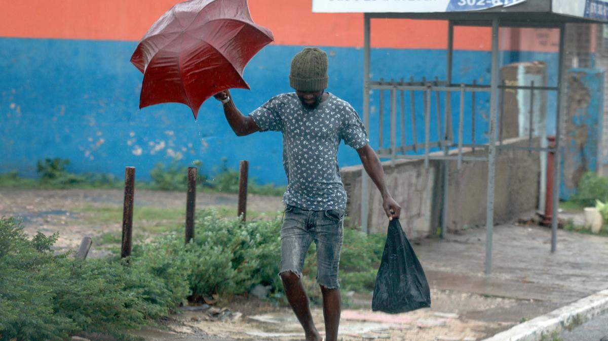 KINGSTON, JAMAICA - JULY 03: A person walks through the wind and rain as Hurricane Beryl spins offshore on July 03, 2024, in Kingston, Jamaica. Category 4 storm Beryl has caused widespread damage in several island nations as it continues to cross the Caribbean. (Photo by Joe Raedle/Getty Images)