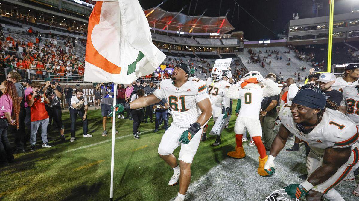 Miami Hurricanes offensive lineman Francis Mauigoa (61) plants the flag into the turf to celebrate the win after the Hurricanes defeat the Florida State Seminoles during their NCAA game at Doak Campbell Stadium in Tallahassee, Florida, on Saturday, October 4, 2025.