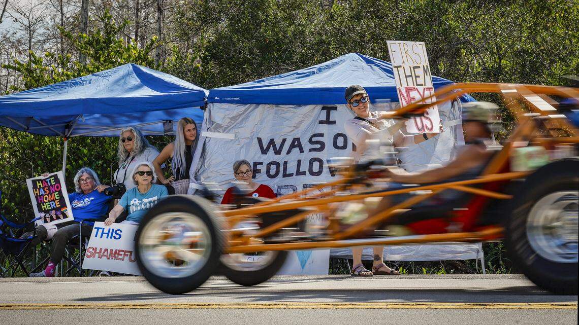 Protestors flash signs outside Alligator Alcatraz as vehicles drive along Tamiami Trail, on Wednesday, November 19, 2025. 