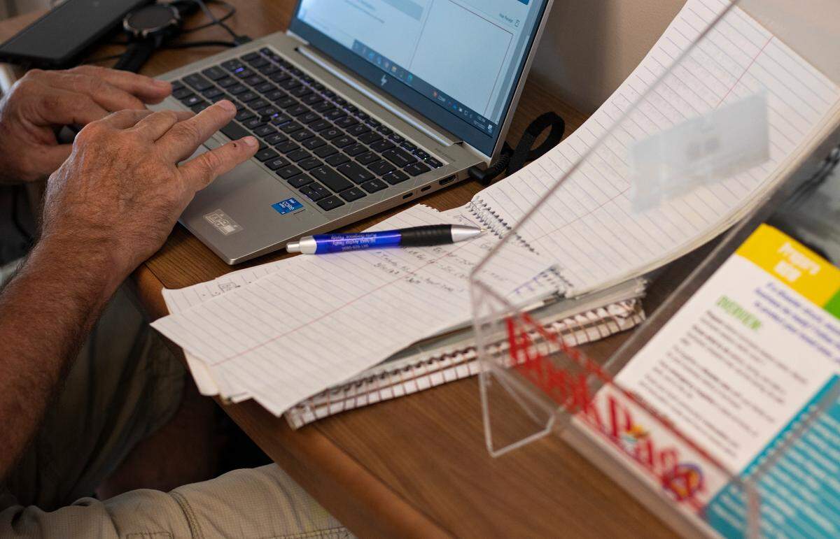 Mark Adkins, 63, Nationwide Financial CPA in compliance and ethics, works at a welcome desk that holds pamphlets at the Punta Gorda Charlotte Library on Tuesday, Oct. 11, 2022.
